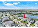 Aerial view of a serene community featuring a lake, beautifully maintained homes, and lush landscaping at 43249 Treadway Dr, Punta Gorda, FL 33982