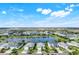 Breathtaking aerial view overlooking a neighborhood surrounding a lake with clear blue skies and fluffy white clouds at 43249 Treadway Dr, Punta Gorda, FL 33982