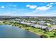 An aerial view features a tranquil lake surrounded by homes in a well-maintained community at 43249 Treadway Dr, Punta Gorda, FL 33982