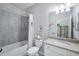Clean bathroom with a single-sink vanity and a shower/tub combination with tiled walls and decorative accents at 43249 Treadway Dr, Punta Gorda, FL 33982
