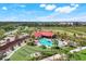 Beautiful community pool area with ample seating, swaying palm trees, and red umbrellas, perfect for relaxation at 43249 Treadway Dr, Punta Gorda, FL 33982