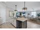 Open floor plan of the kitchen showcasing an island with granite countertops, and a view into the dining and living room at 43249 Treadway Dr, Punta Gorda, FL 33982