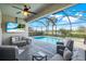 Covered lanai with a pool, a spa, outdoor seating, and a mounted TV, ideal for enjoying the outdoors in comfort at 43249 Treadway Dr, Punta Gorda, FL 33982