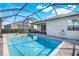 The screened in ground pool is nestled into private landscaping and is adjacent to the patio at 43249 Treadway Dr, Punta Gorda, FL 33982