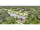 An aerial view showcases this home nestled among lush greenery and neighboring houses at 4413 S San Mateo Dr, North Port, FL 34288