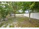 A picturesque backyard featuring mature trees and a privacy fence, creating a peaceful outdoor retreat at 4413 S San Mateo Dr, North Port, FL 34288