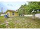 View of backyard with grassy area and mature trees, offering a serene outdoor space at 4413 S San Mateo Dr, North Port, FL 34288