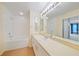 Bright bathroom featuring tub, shower, vanity with large mirror, and new lighting at 4413 S San Mateo Dr, North Port, FL 34288