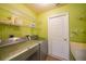 A laundry room featuring a washer, dryer, sink, shelving, and access to backyard at 4413 S San Mateo Dr, North Port, FL 34288