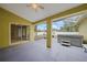 A screened-in patio featuring a hot tub, overhead fan, and sliding glass doors at 4413 S San Mateo Dr, North Port, FL 34288