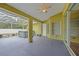 A screened-in patio featuring a hot tub, overhead fan, and access to the backyard at 4413 S San Mateo Dr, North Port, FL 34288