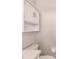 Bright bathroom featuring white cabinets, a modern shelf, and a comfortable toilet at 444 Edgewood Rd, Venice, FL 34293