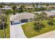 Inviting waterfront home with lush landscaping, screened in porch, and a long concrete driveway at 444 Edgewood Rd, Venice, FL 34293