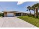 Charming single-story home with stone accents, a screened in porch, and a spacious concrete driveway at 444 Edgewood Rd, Venice, FL 34293