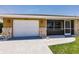 Lovely home exterior featuring stone accents, an attached garage, and a screened in porch at 444 Edgewood Rd, Venice, FL 34293