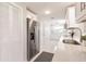 Modern kitchen with stainless refrigerator, white cabinetry and countertops, and recessed lighting at 444 Edgewood Rd, Venice, FL 34293