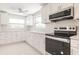 Modern kitchen featuring white cabinets, stainless appliances, and speckled flooring at 444 Edgewood Rd, Venice, FL 34293
