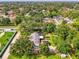 Aerial view showcasing a home with a pool, large yard, mature trees, and neighborhood surroundings at 4511 Wilkinson Rd, Sarasota, FL 34233