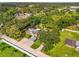 Aerial perspective capturing the property with a long driveway, carport, lush greenery, and pool at 4511 Wilkinson Rd, Sarasota, FL 34233