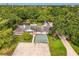 Expansive single-story home featuring lush landscaping, a covered pool, and a detached garage surrounded by mature trees at 4511 Wilkinson Rd, Sarasota, FL 34233
