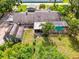 Aerial view of a property showcasing a large home, screened pool, outbuilding, and well-manicured lawn at 4511 Wilkinson Rd, Sarasota, FL 34233