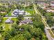 Expansive aerial view featuring lush landscaping surrounding a home with a large pool and manicured lawn at 4511 Wilkinson Rd, Sarasota, FL 34233