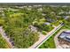 High angle shot showcases the residence with mature trees, green lawn, and a long drive at 4511 Wilkinson Rd, Sarasota, FL 34233