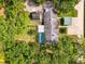 Aerial view of the property with a pool, mature trees, and a carport, showcasing the layout and backyard at 4511 Wilkinson Rd, Sarasota, FL 34233