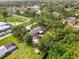 Aerial view of the property showcasing the home, pool, surrounding trees, and neighborhood features at 4511 Wilkinson Rd, Sarasota, FL 34233