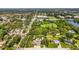 Elevated shot of a tree-covered property with a pool, carport, and a long driveway, in a lush, green setting at 4511 Wilkinson Rd, Sarasota, FL 34233