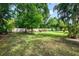 Secluded backyard features lush green grass, mature trees, a charming swing, and a private, peaceful atmosphere at 4511 Wilkinson Rd, Sarasota, FL 34233