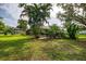 Lush backyard featuring a screened-in pool area with mature palm trees and manicured lawn at 4511 Wilkinson Rd, Sarasota, FL 34233