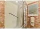 Tiled bathroom features a tub with shower and a grab bar for safety at 4511 Wilkinson Rd, Sarasota, FL 34233