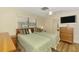 Comfortable bedroom with two beds, ceiling fan, and a dresser with television on top at 4511 Wilkinson Rd, Sarasota, FL 34233