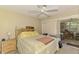 Cozy bedroom with natural light, ceiling fan, and sliding door to a bright sunroom at 4511 Wilkinson Rd, Sarasota, FL 34233