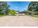Inviting home featuring a covered parking area and a well-maintained front yard with beautiful landscaping at 4511 Wilkinson Rd, Sarasota, FL 34233