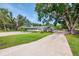Well-maintained property with a long driveway, covered parking, and lush green lawn showcasing a tranquil setting at 4511 Wilkinson Rd, Sarasota, FL 34233