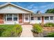 Charming home exterior showcasing brick accents, white siding, manicured landscaping, and a welcoming front entrance at 4511 Wilkinson Rd, Sarasota, FL 34233
