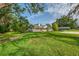Spacious front yard and charming home with mature trees and landscaped features at 4511 Wilkinson Rd, Sarasota, FL 34233
