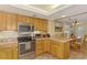 A kitchen featuring stainless steel appliances, light wood cabinets, and modern fixtures at 4511 Wilkinson Rd, Sarasota, FL 34233