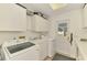 Bright laundry room with washer, dryer, sink, and plenty of storage at 4511 Wilkinson Rd, Sarasota, FL 34233