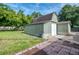 The outbuilding features wooden siding, a tall barn roof, and a white garage door, nestled on a green lawn at 4511 Wilkinson Rd, Sarasota, FL 34233