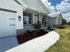 Inviting exterior elevation showcasing a manicured lawn, elegant stone accents, and a welcoming front porch at 9469 Spring Cir, Port Charlotte, FL 33981