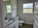 Stylish bathroom with granite countertop vanity, white cabinets, and tiled floors at 10023 Greetings St, Port Charlotte, FL 33981