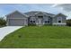 Charming gray single-story home with well-manicured lawn and attached two-car garage at 10023 Greetings St, Port Charlotte, FL 33981