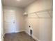 Functional laundry room boasts a wire rack shelving unit and convenient access to a door at 10023 Greetings St, Port Charlotte, FL 33981