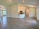 Open-concept living space with neutral tones and tiled floors leading to an eat-in kitchen at 10023 Greetings St, Port Charlotte, FL 33981