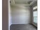 Bright living room featuring elegant tray ceilings, tile flooring, and plenty of natural light from a large window at 10023 Greetings St, Port Charlotte, FL 33981