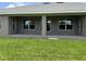 Covered patio showing symmetrical windows and door to the backyard, perfect for enjoying outdoor living at 10023 Greetings St, Port Charlotte, FL 33981