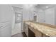 Bathroom vanity featuring a granite countertop and wood cabinets, leading to bedroom at 1057 Presque Isle Dr, Port Charlotte, FL 33952